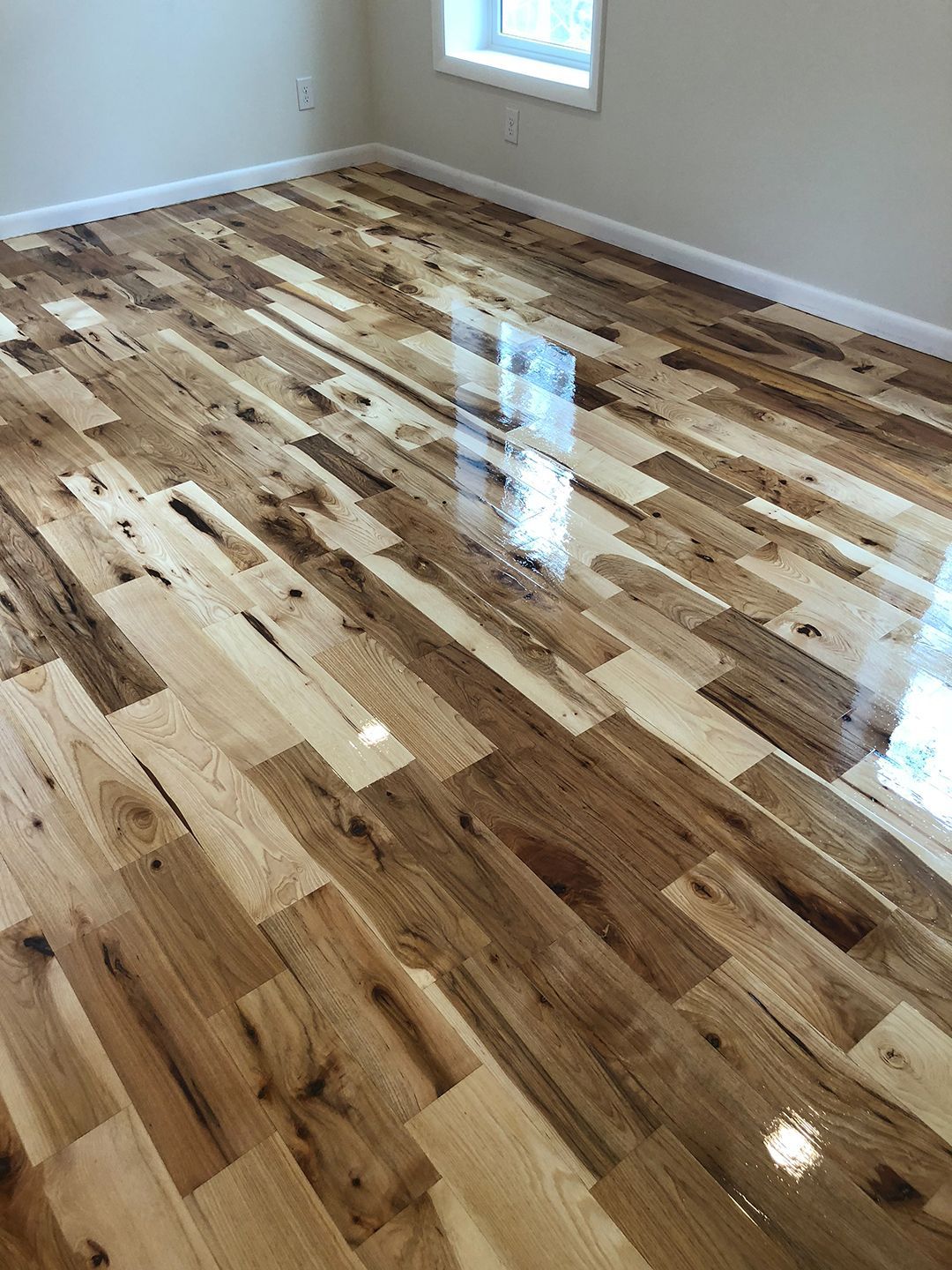 A room with a wooden floor and a window.