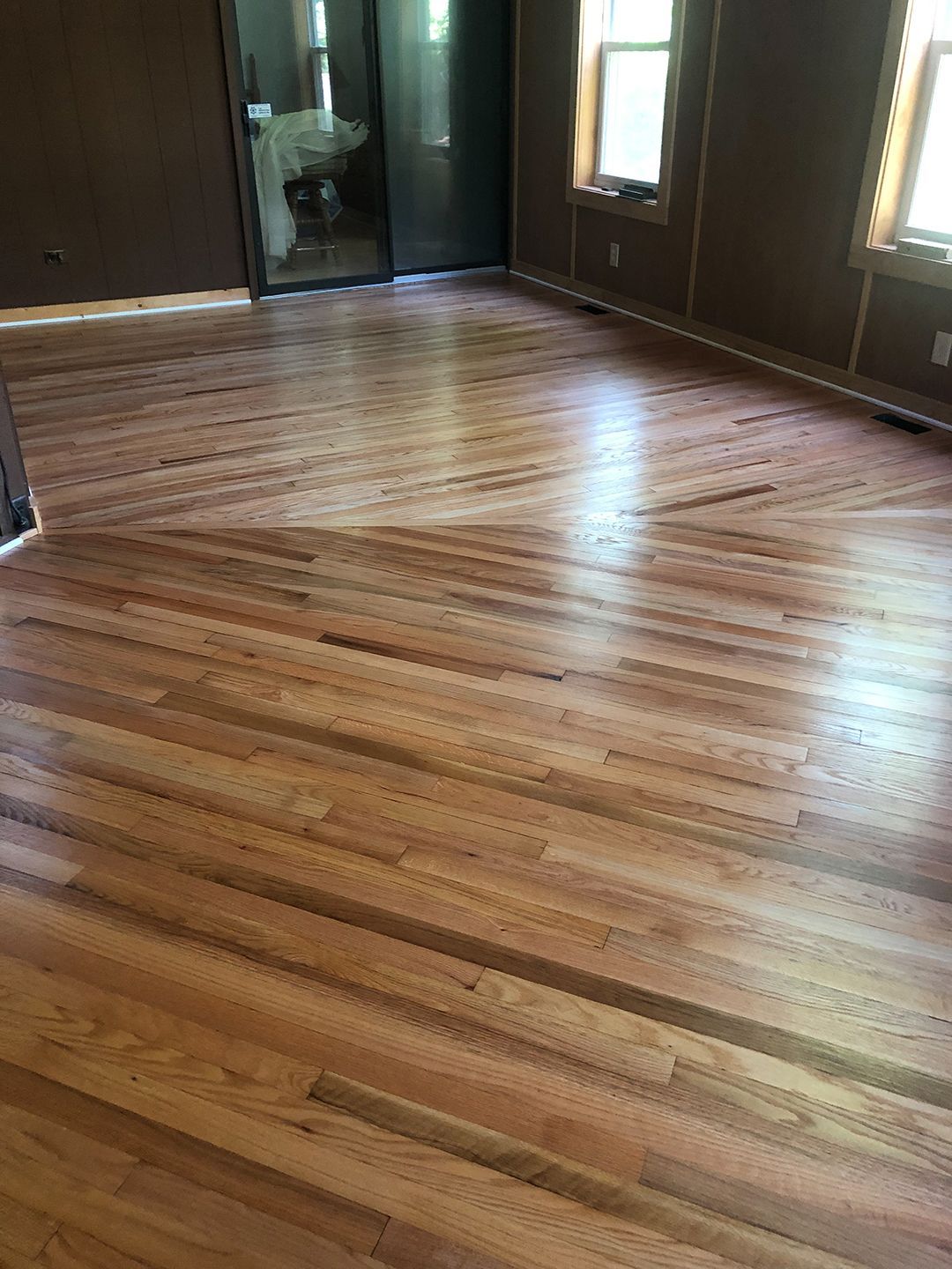 A living room with hardwood floors and a sliding glass door.