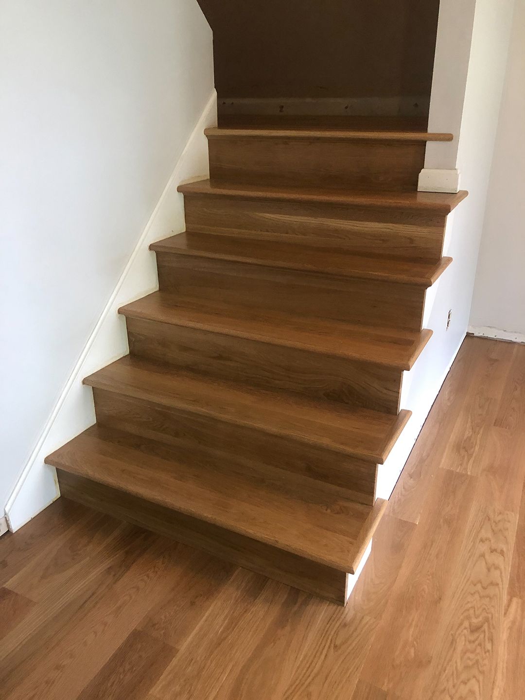 A wooden staircase with hardwood floors in a house.