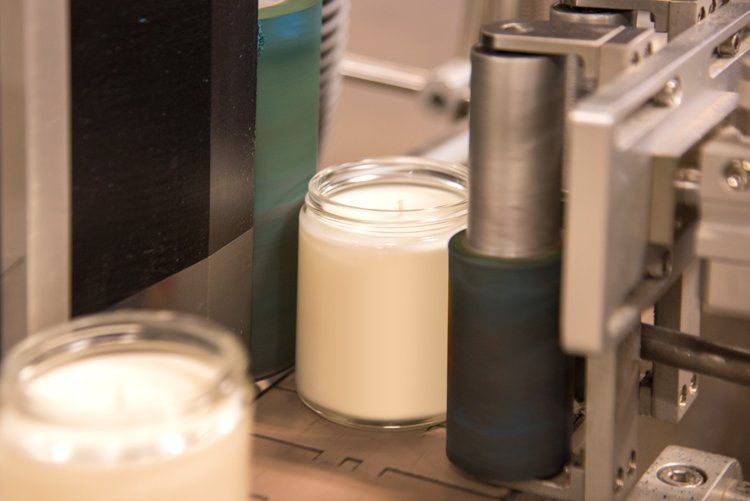 A machine is filling jars of milk on a conveyor belt.