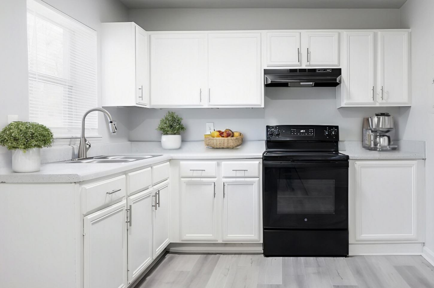 A kitchen with white cabinets , a black stove , and a sink.