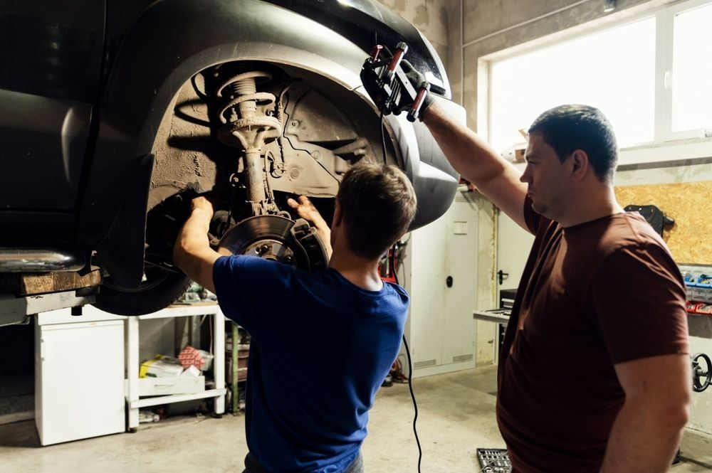 Two Mechanics Working on a Car in a Garage — Barnco Automotive Repairs in Taminda, NSW