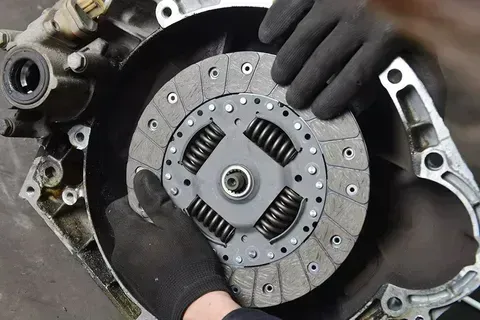 Hands in Black Gloves Installing a Clutch Disc — Barnco Automotive Repairs in Taminda, NSW