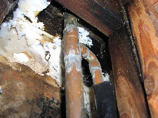A close up of a pipe in a wooden wall.