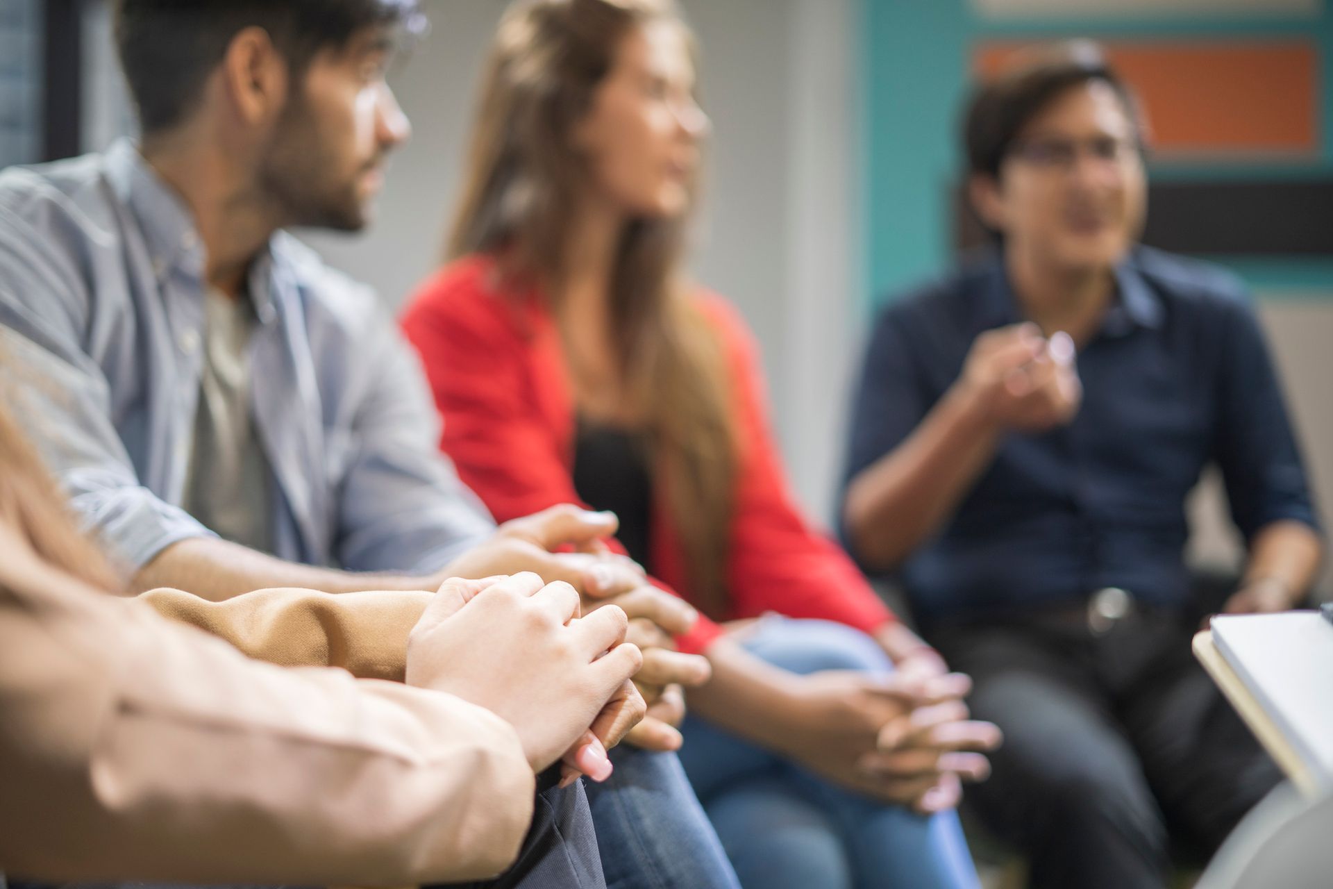 Individuals engaging in a discussion during a group drug addiction therapy session.