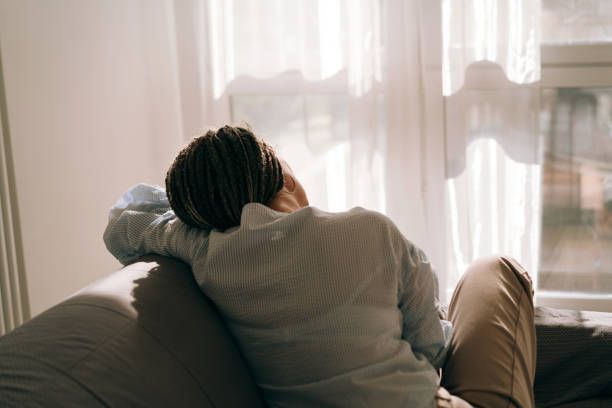 Portrait of a woman sitting on the sofa and looking out the window.