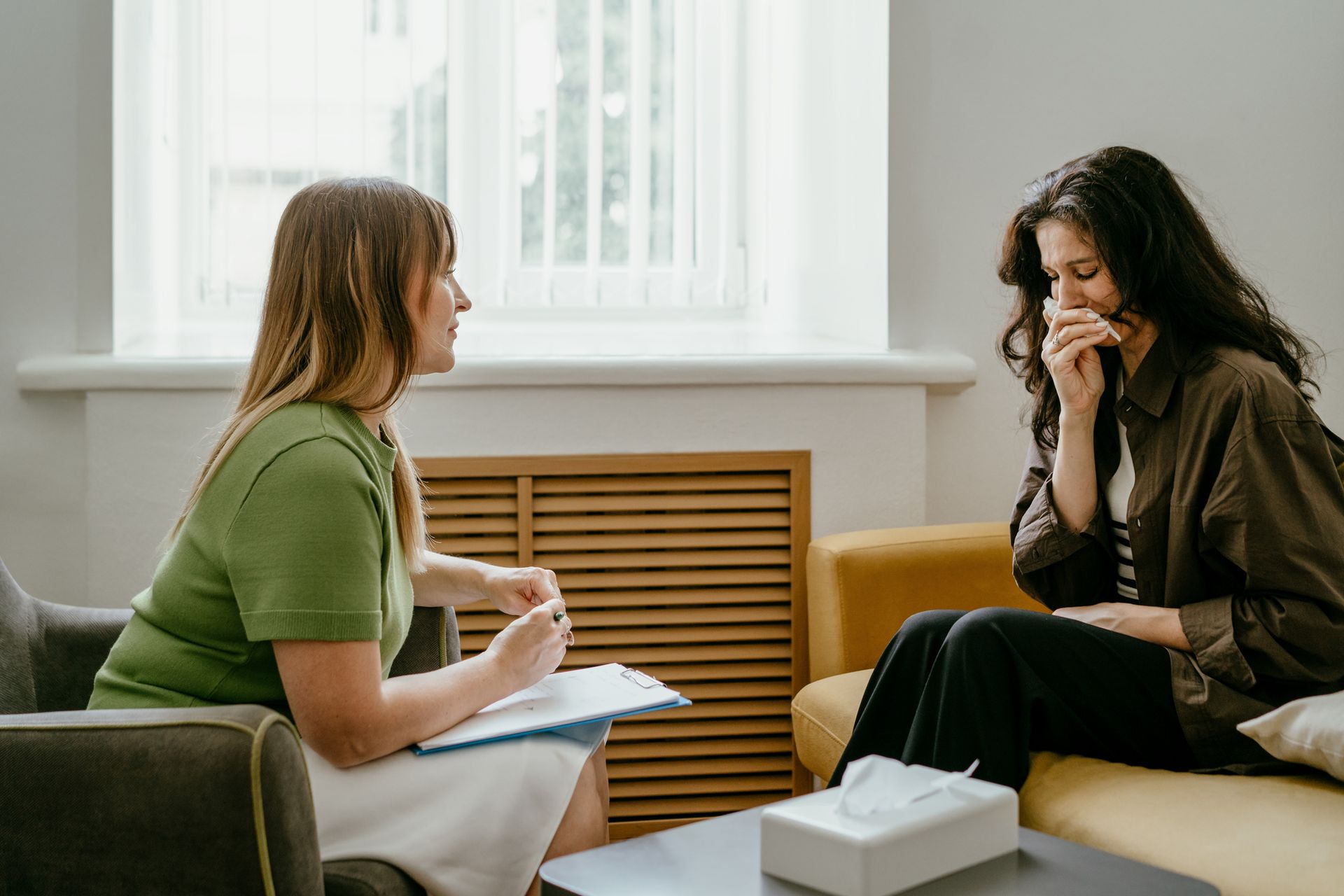 A therapist is talking to a patient who is crying.