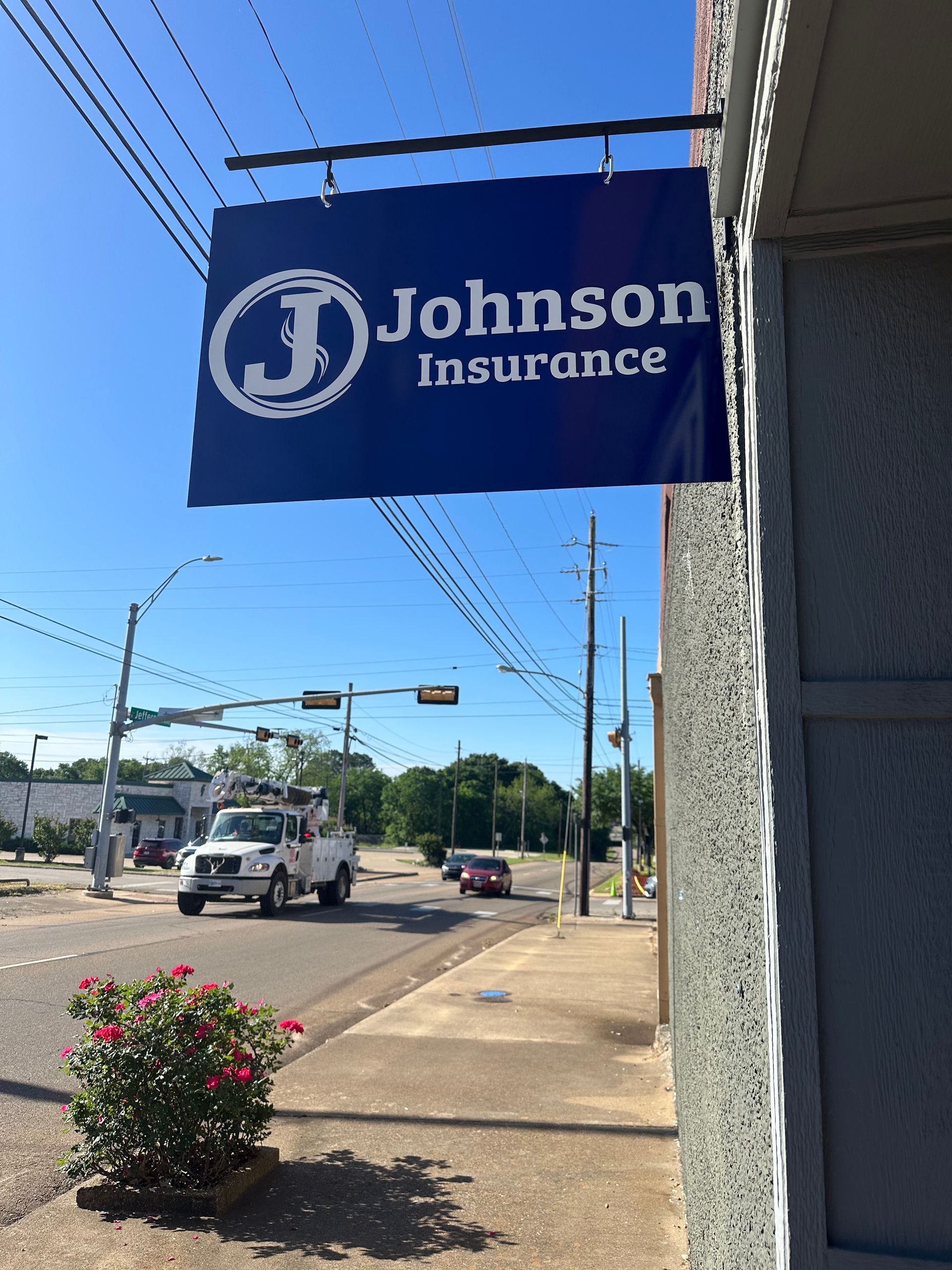 A johnson insurance sign hangs from the side of a building