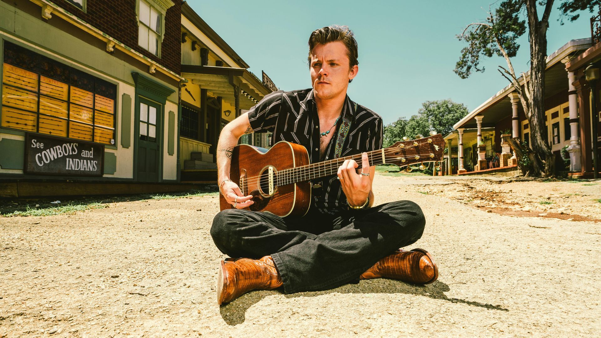 A red canoe is sitting on the shore of a river.