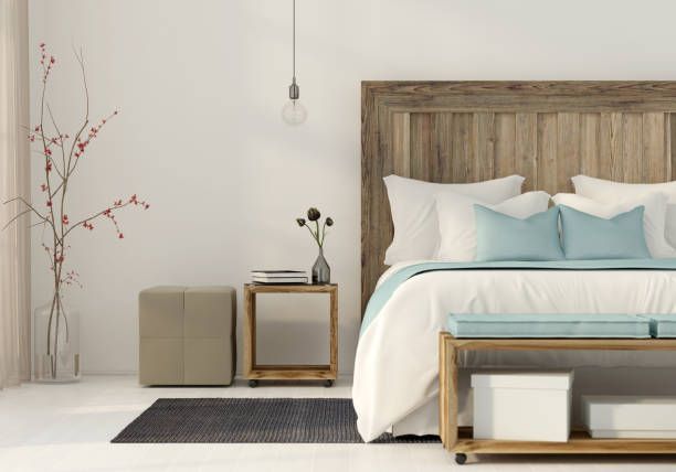 Bedroom with wooden headboard, white bedding, turquoise accents, light fixture, side table, and bench.