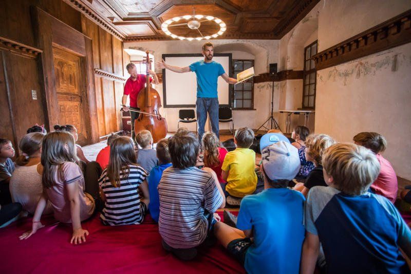 Ein Mann hält vor einer Gruppe von Kindern einen Vortrag.