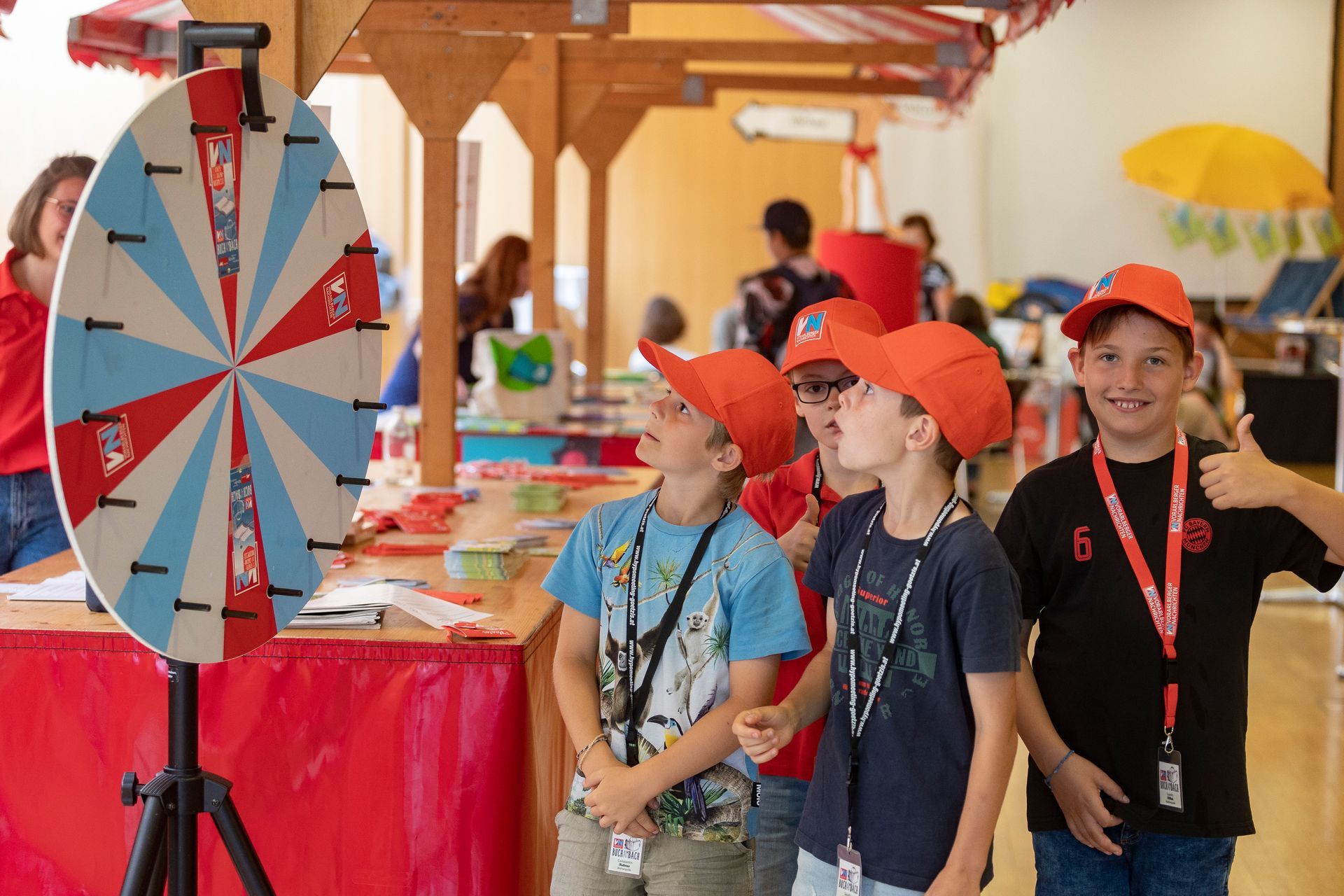 Eine Gruppe junger Jungen steht vor einem Spinnrad.