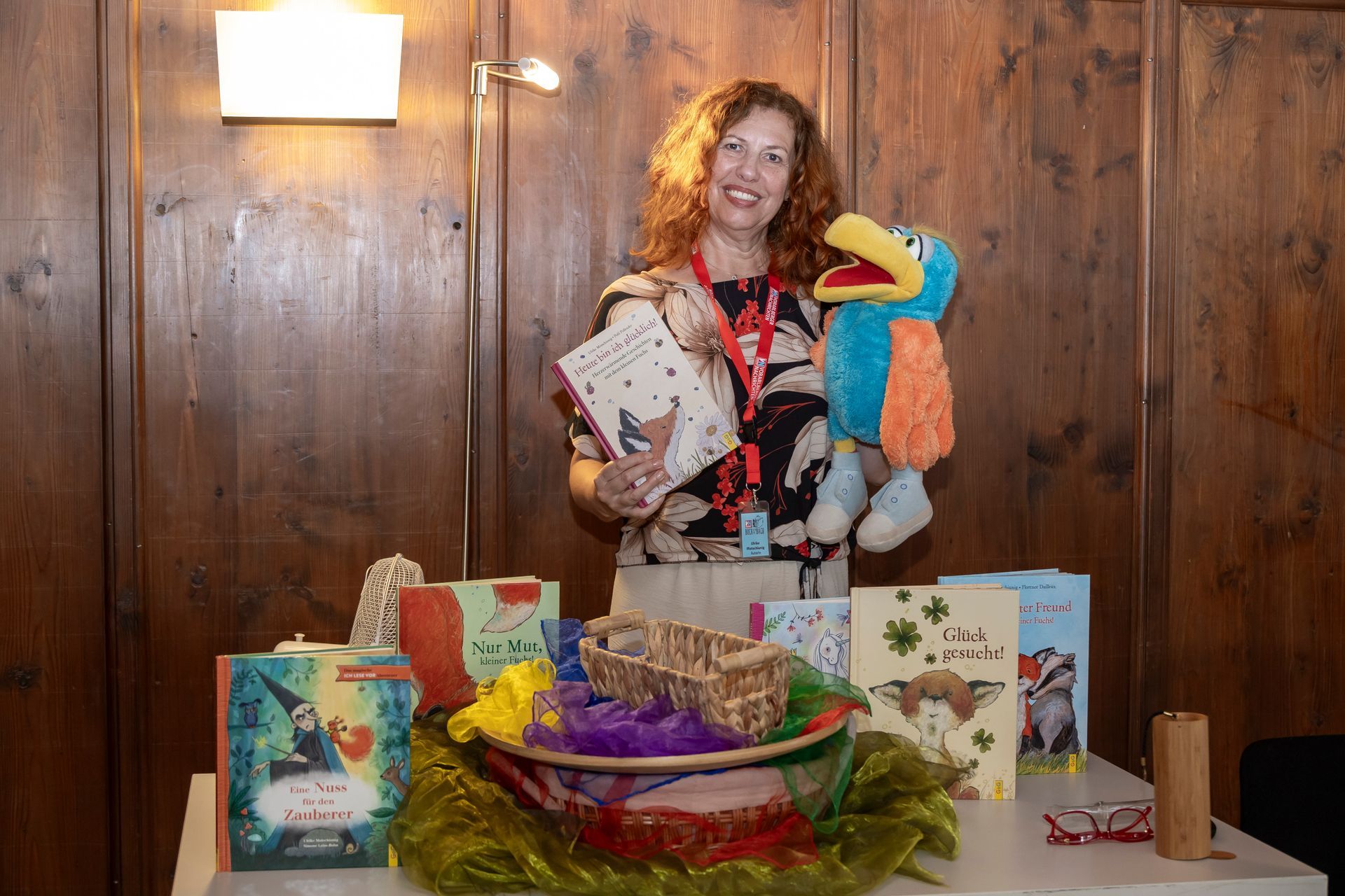Eine Frau steht vor einem Tisch und hält ein Stofftier.