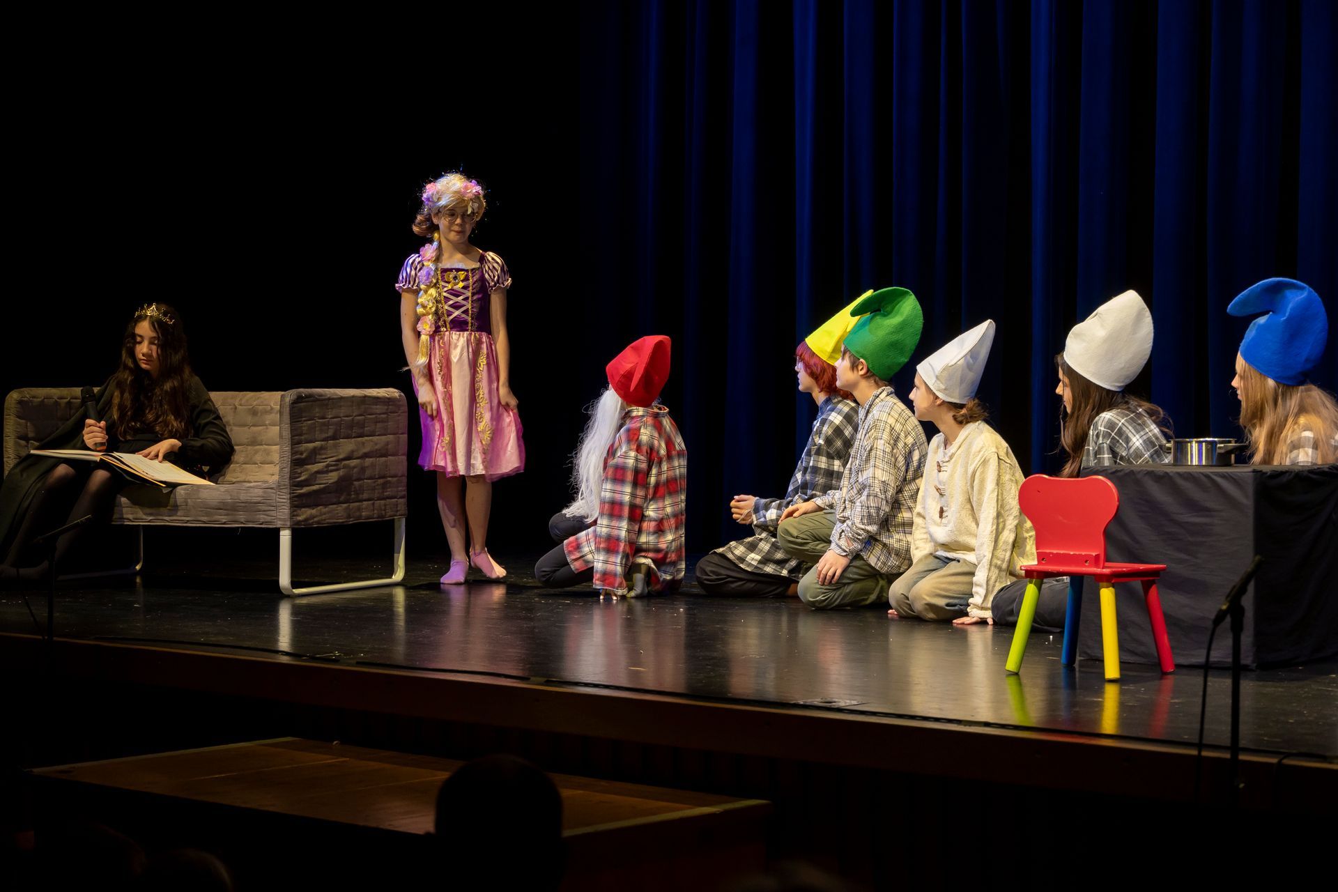 Eine Gruppe als Zwerge verkleideter Kinder steht auf einer Bühne.