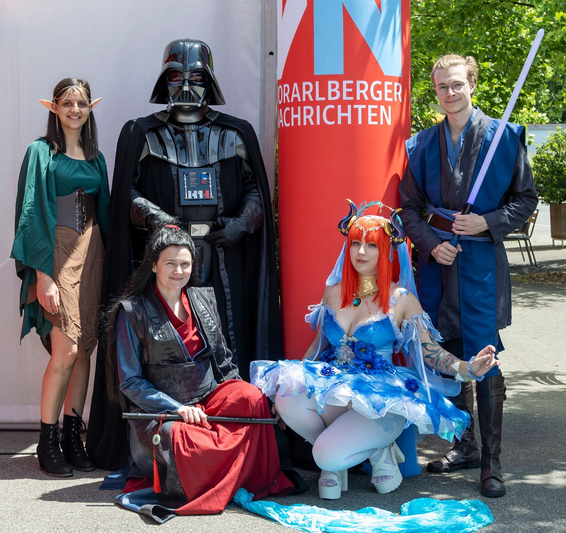 Eine Gruppe von Menschen in Kostümen posiert für ein Foto mit Darth Vader