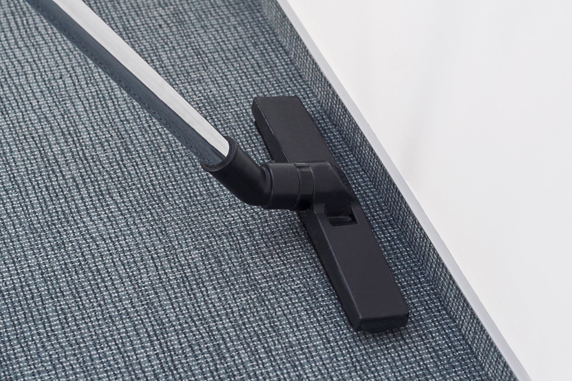 A vacuum cleaner is cleaning a carpet in a room.