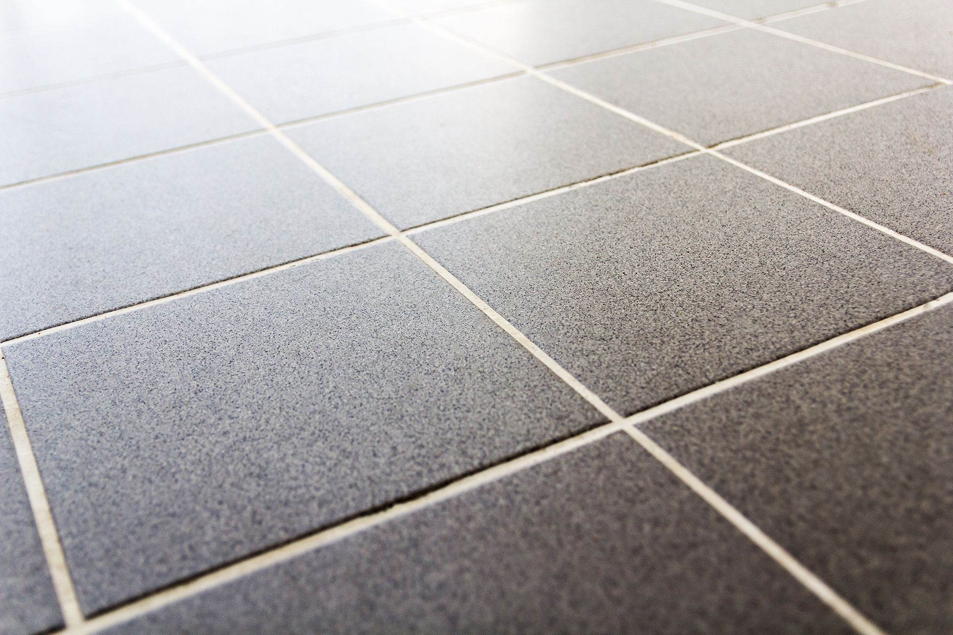 A close up of a tiled floor with white grout