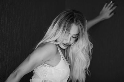 A black and white photo of a woman in a white dress dancing.