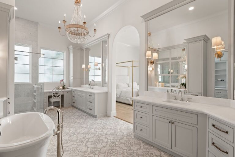 A bathroom with two sinks , a bathtub , and a chandelier.