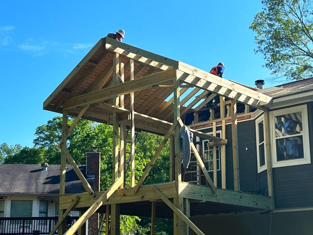 A house is being remodeled with a deck being built on top of it.