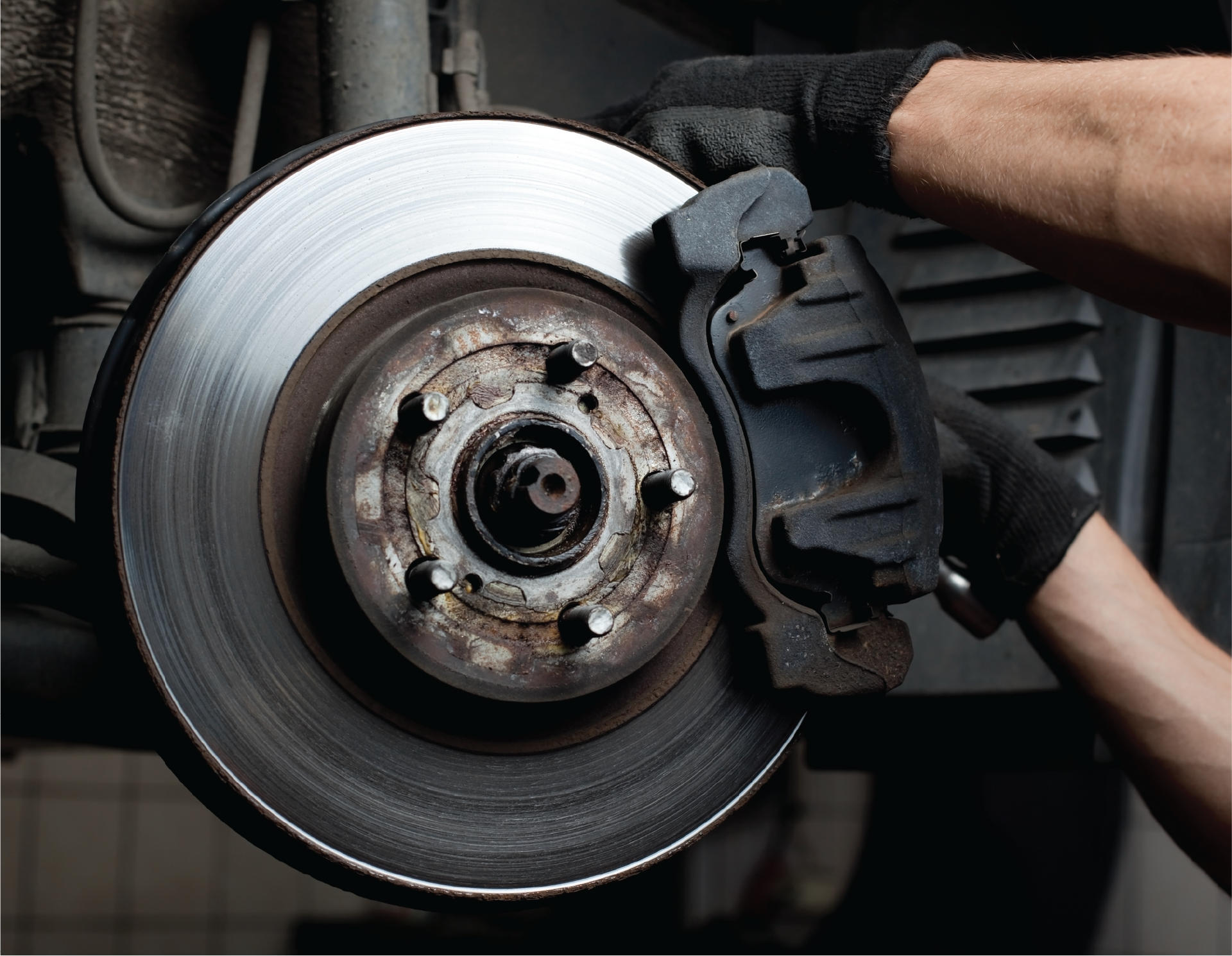 A person is fixing a brake pad on a car.