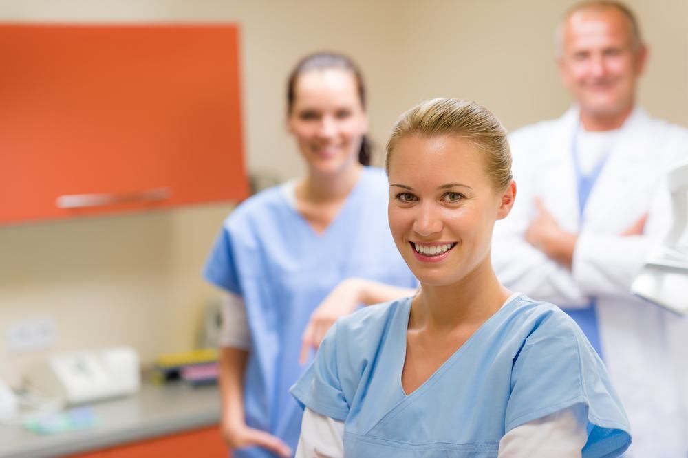 A Group Of Doctors And Nurses Are Posing For A Picture In A Hospital Room — Dental Care Smithfield In Trinity Beach, QLD