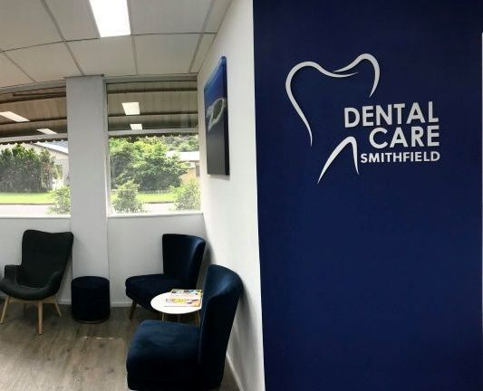 A Dentist Is Examining A Patient 's Teeth In A Dental Office — Dental Care Smithfield In Smithfield, QLD