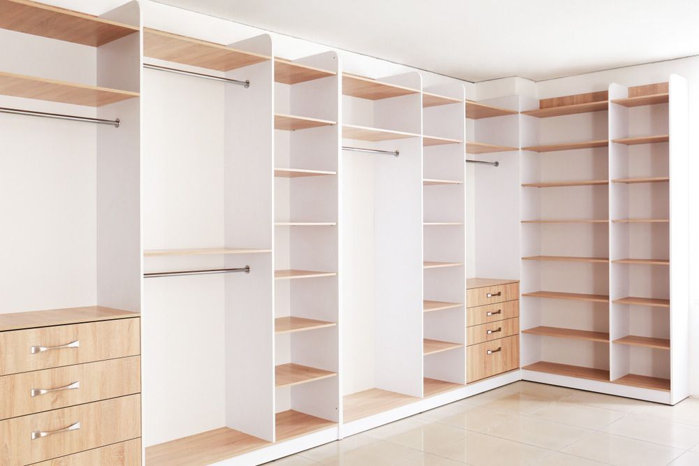 An Empty Walk in Closet With Lots of Shelves and Drawers — Bruce Smith Cabinets in Kingscliff, NSW