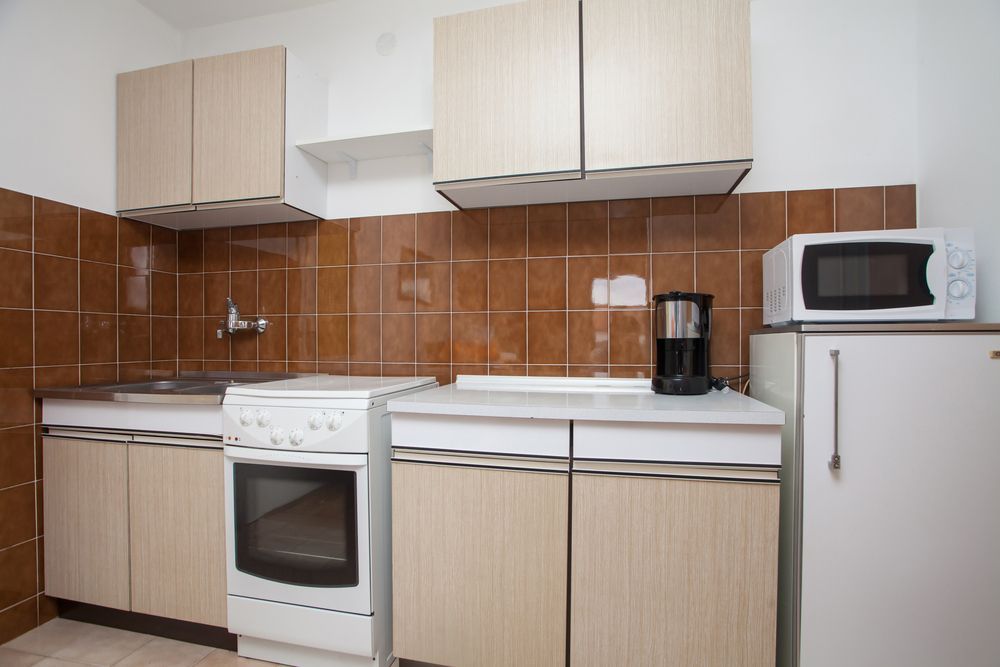 A Kitchen With a Stove, Refrigerator, Microwave and Coffee Maker — Bruce Smith Cabinets in Bray Park, NSW