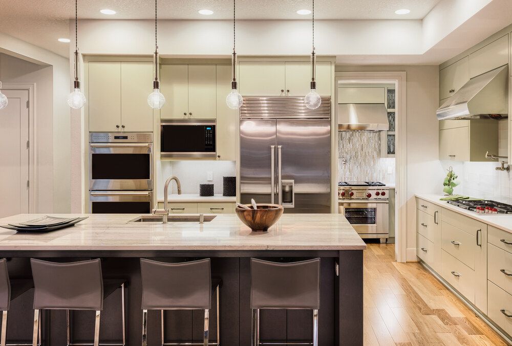 A Kitchen With Stainless Steel Appliances and a Large Island — Bruce Smith Cabinets in Bray Park, NSW