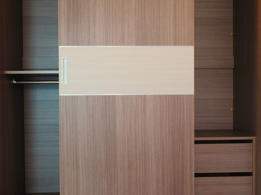 A Wooden Wardrobe With Sliding Doors and Drawers — Bruce Smith Cabinets in Bray Park, NSW