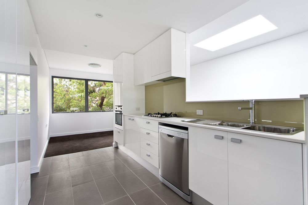 A Kitchen With White Cabinets and Stainless Steel Appliances — Bruce Smith Cabinets in Bray Park, NSW