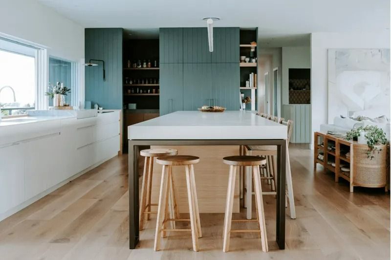A Kitchen With a Large Island and Stools in It — Bruce Smith Cabinets in Bray Park, NSW