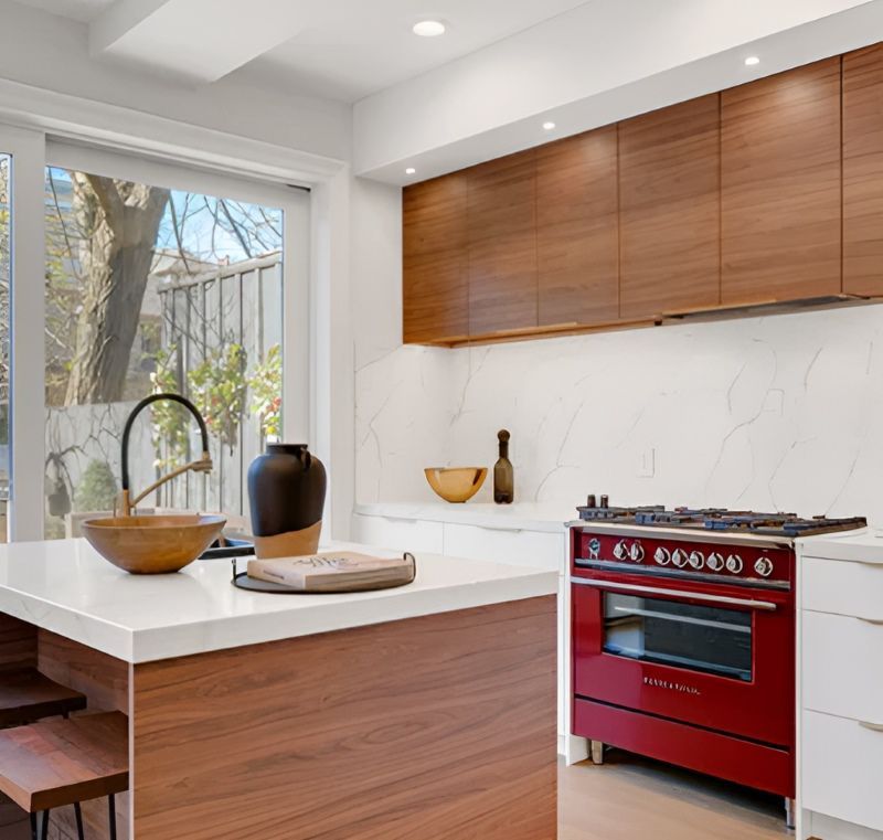 A Kitchen With a Red Stove and a Wooden Island — Bruce Smith Cabinets in Bray Park, NSW