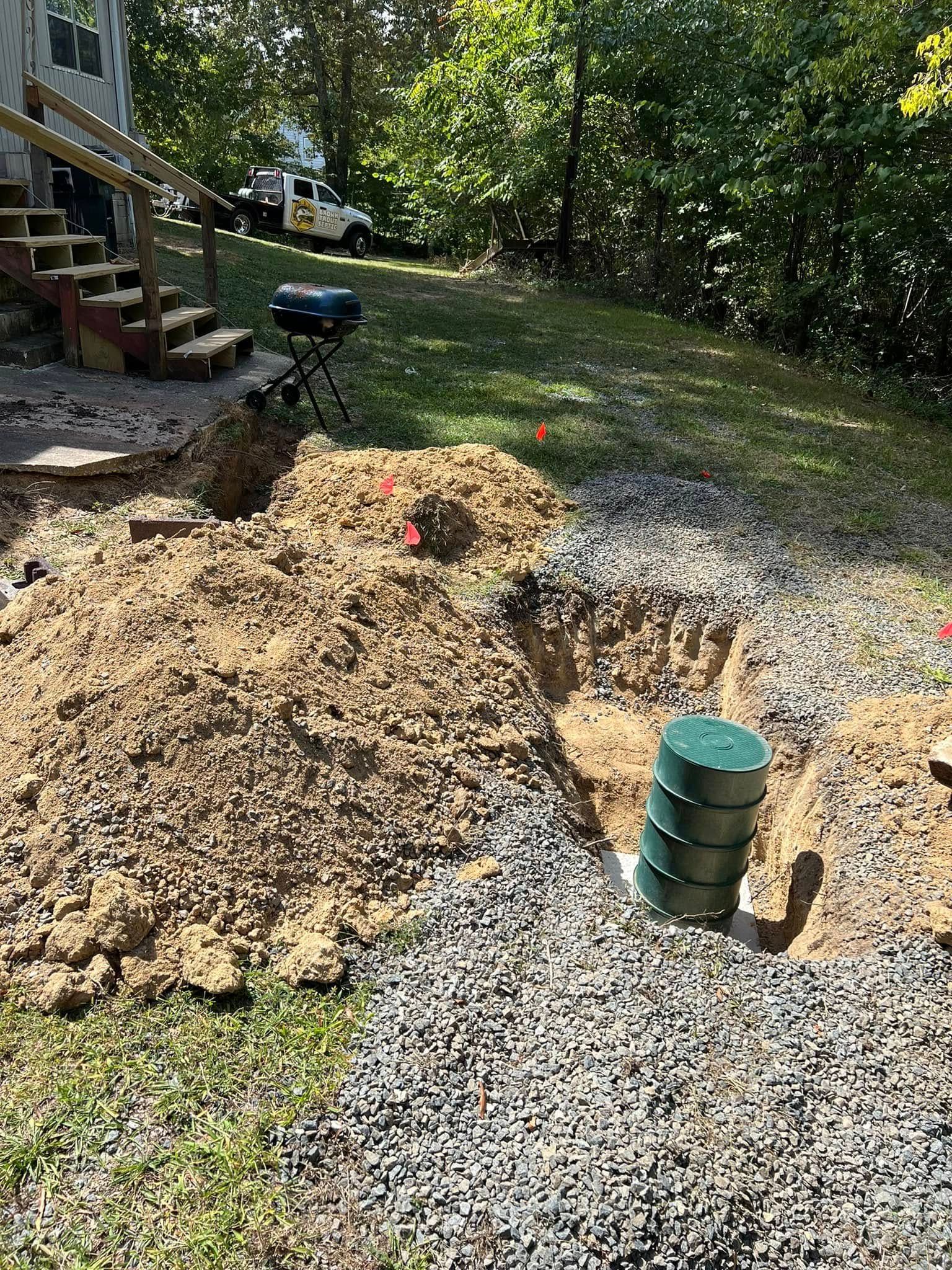 A large pile of dirt and gravel in a yard next to a house.