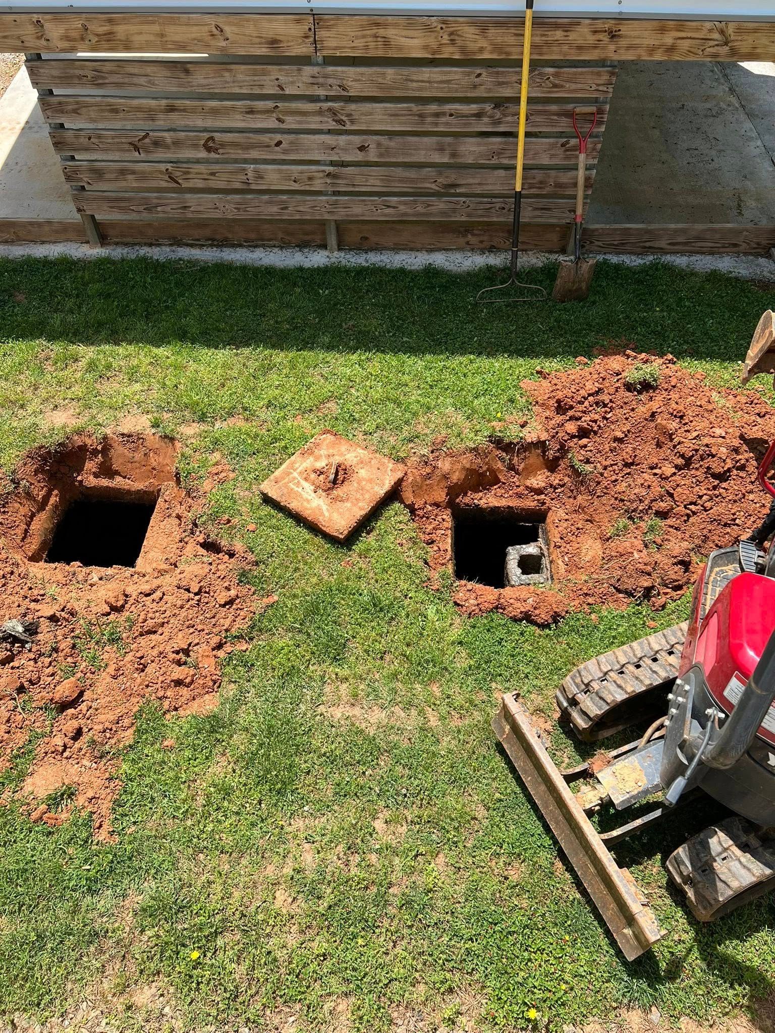 A green pipe is being installed in a yard next to a house.