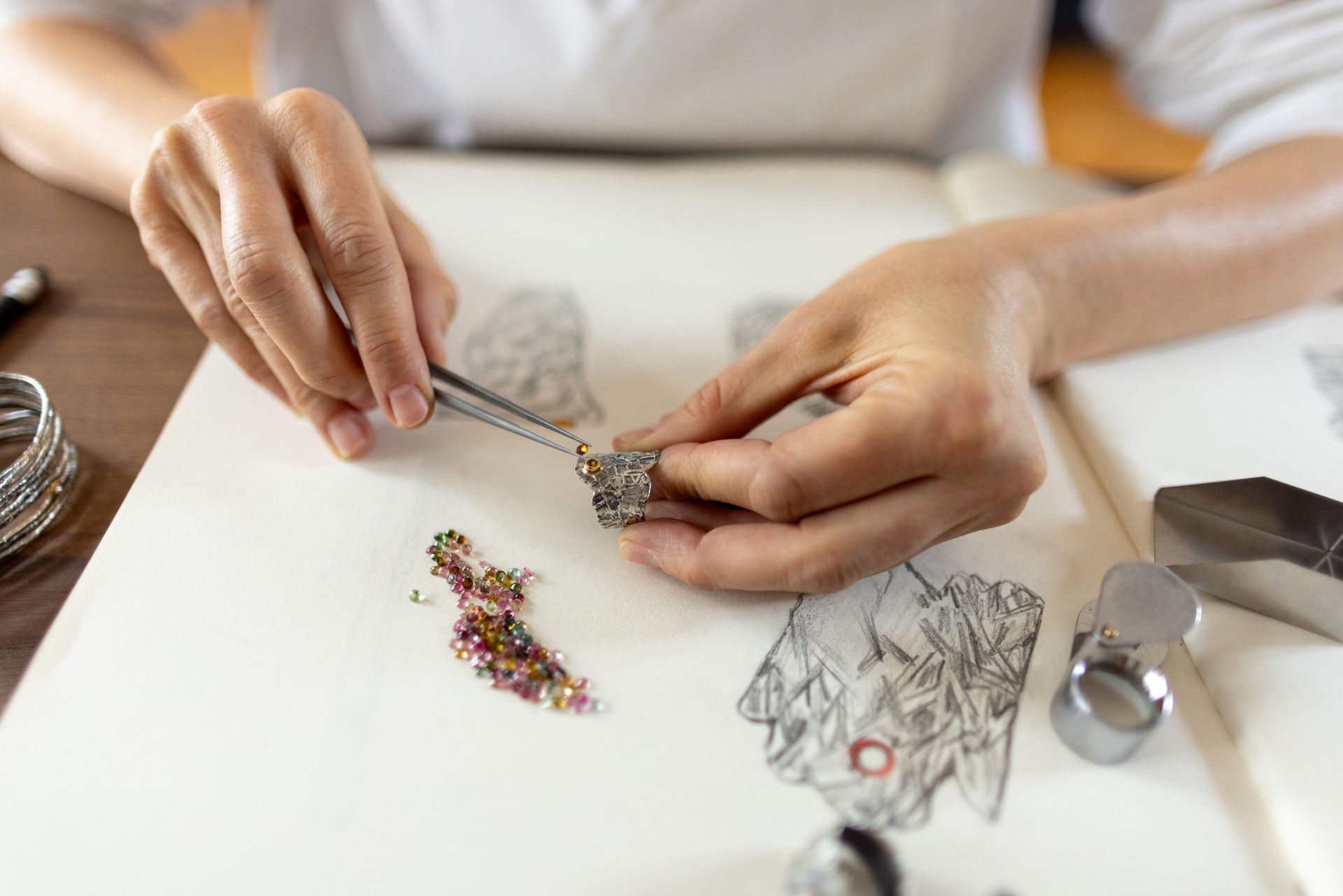 Woman is making jewelry in her workshop studio.