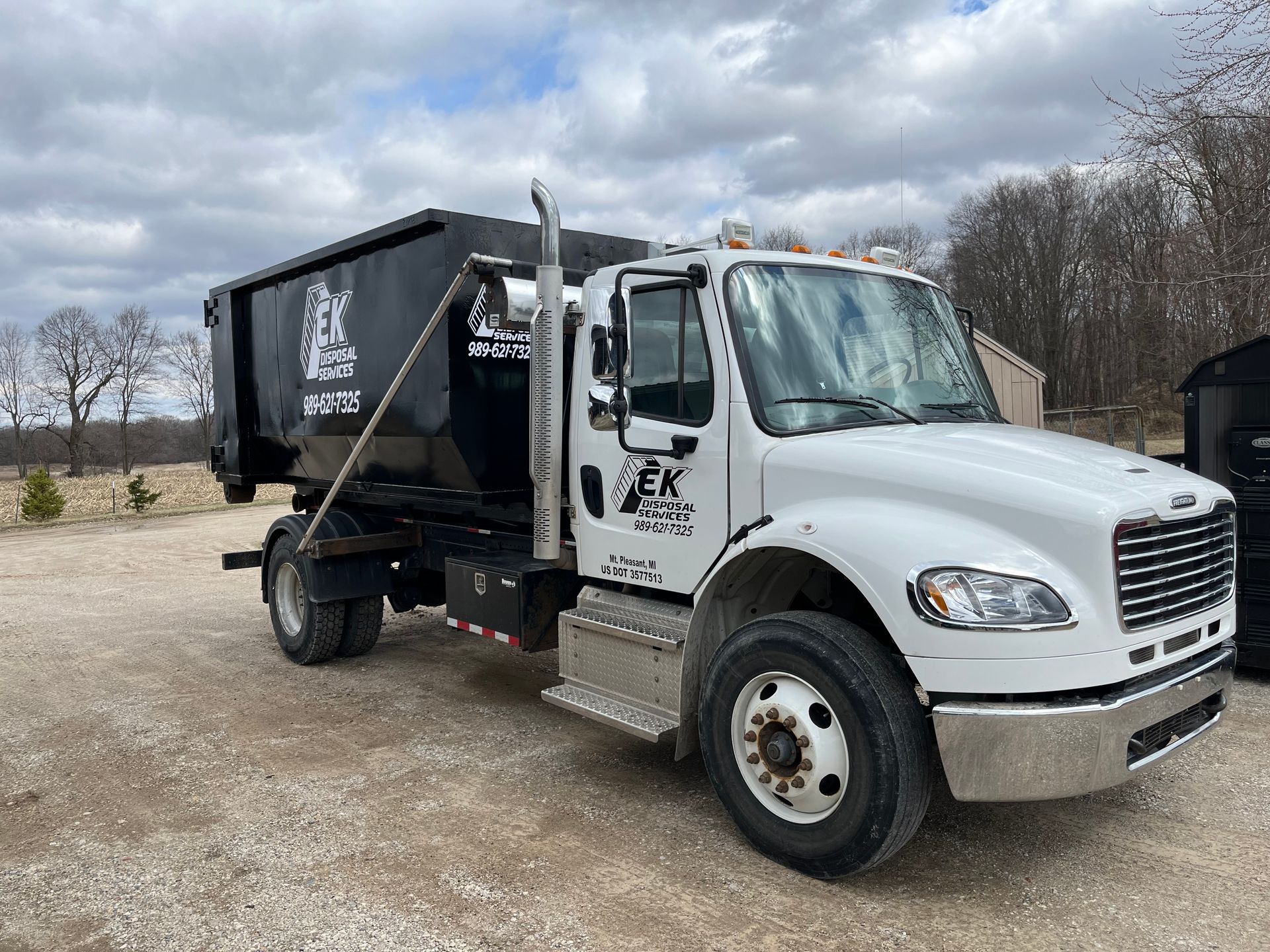 Green Isabella County garbage truck parked on a residential street.