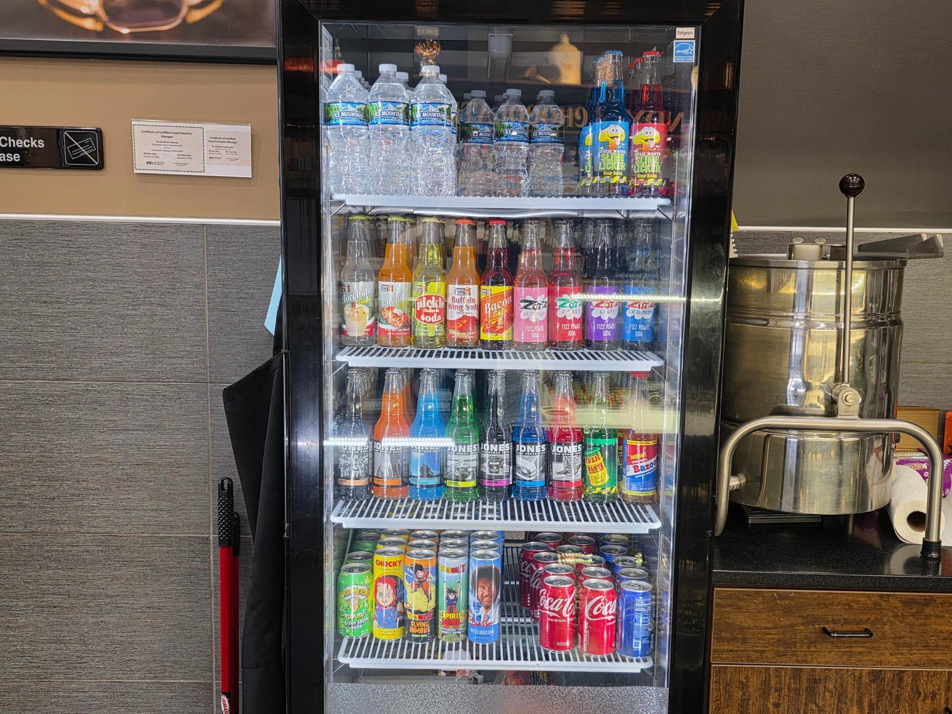 Refrigerator stocked with various bottled and canned drinks.