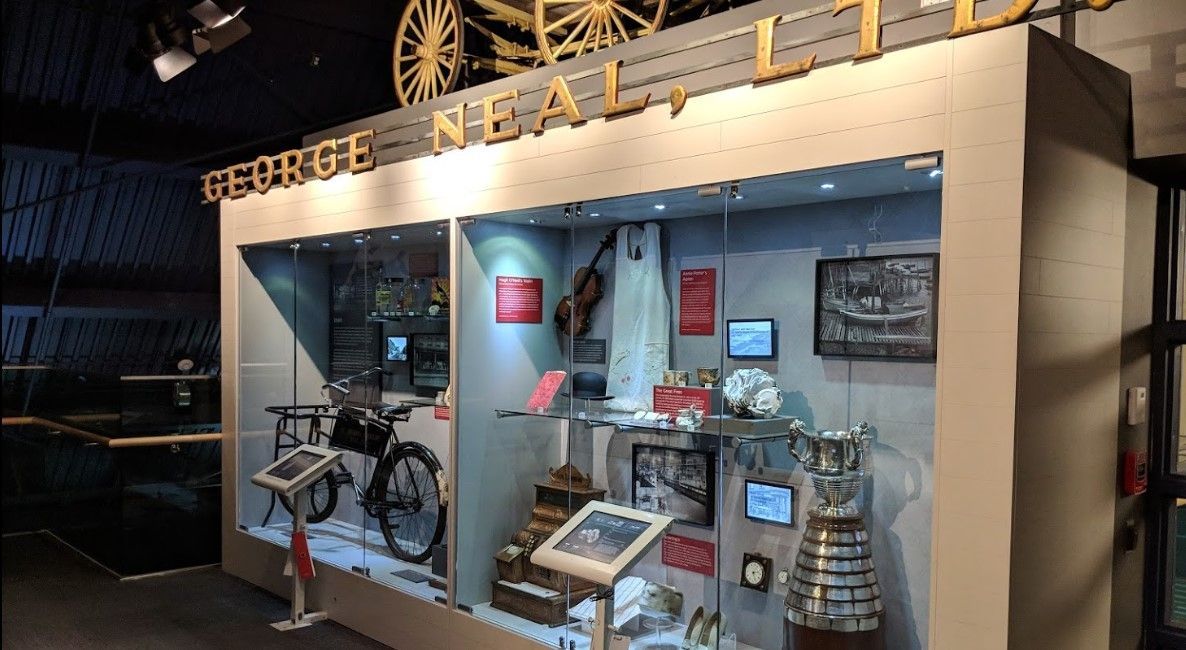 Museum exhibit: artifacts and historic items displayed in glass cases, labeled
