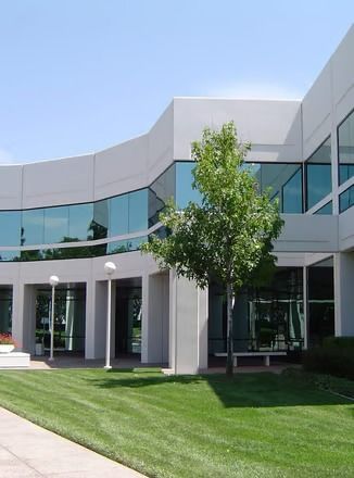 A large building with a lot of windows and a tree in front of it