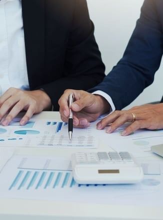 A man is holding a pen while sitting at a table with a woman.