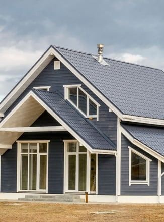 A blue house with a white trim and a blue roof