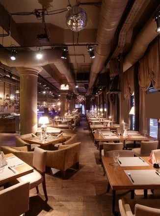 A restaurant filled with tables and chairs and a disco ball hanging from the ceiling.