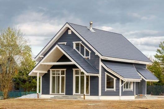 A blue house with a white trim and a gray roof