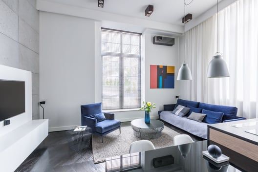 A living room with a couch , chair , table and television.