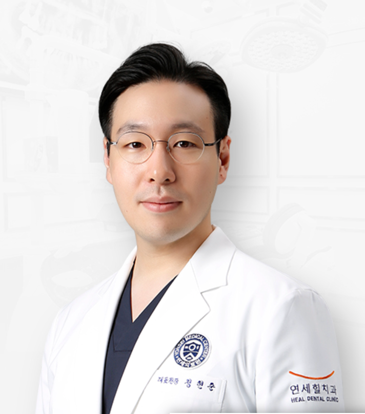 A Korean dentist in a white coat, wearing glasses, looking forward with a neutral expression.