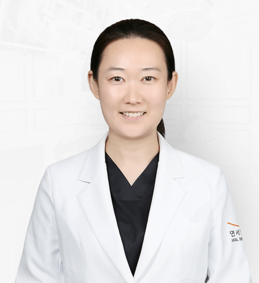 Smiling Asian woman in a white lab coat, possibly a doctor, against a blurred background.