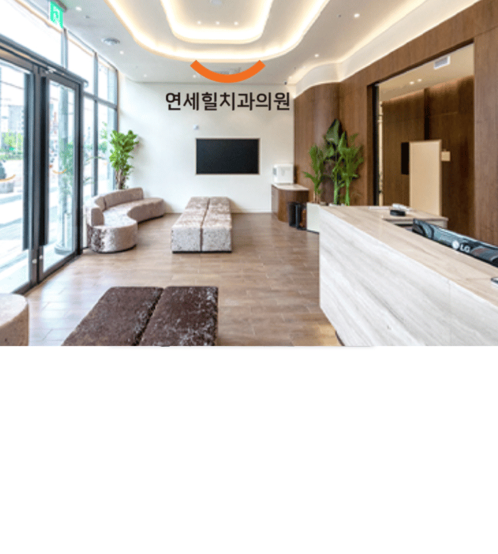 Modern dental clinic waiting area with seating and reception desk.