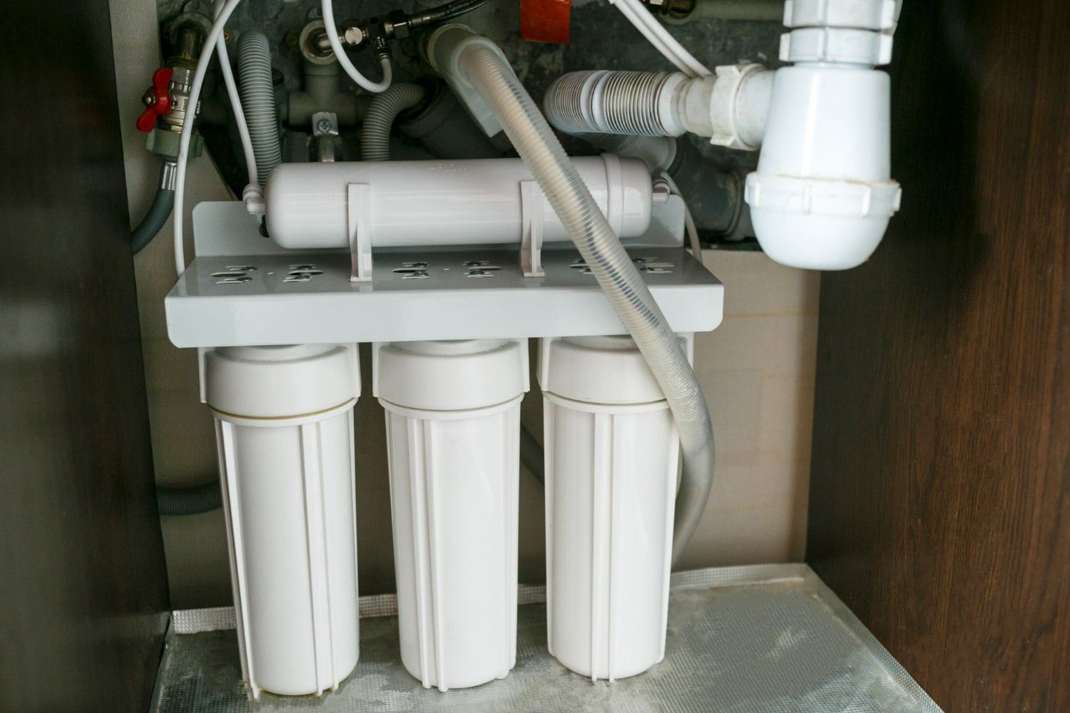 Undersink Water Filter System With Three White Canister Filters and a Small Tank — VR Marsden Plumbing in Red Rock, NSW